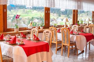 艾森巴哈Waldhotel Auerhahn B&B Bed & Breakfast的用餐室配有桌椅和红色餐巾