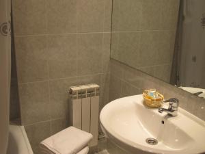 拉武埃尔达图尔摩酒店的一间带水槽、卫生间和镜子的浴室