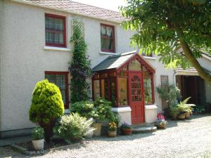 SulbyBallacowell Cottage的一座有红门和一些植物的房子