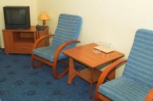 弗沃茨瓦韦克Hotel Kujawy的一间设有两把椅子、一张桌子和一台电视的房间