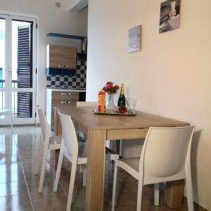 奥斯图尼Aurasia Alla Marina的一间带木桌和白色椅子的用餐室