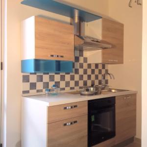奥斯图尼Aurasia Alla Marina的一个带木制橱柜和水槽的厨房