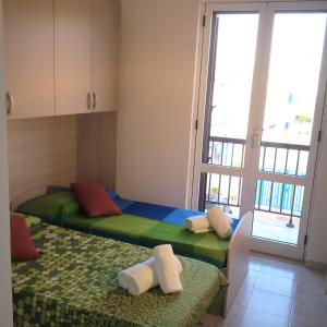 奥斯图尼Aurasia Alla Marina的一间卧室设有两张床和大窗户