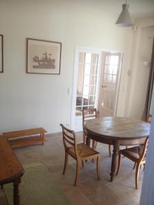 维莱尔维尔Les Grands Houx的一间带木桌和椅子的用餐室