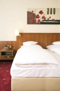 帕德博恩夜莺沃德酒店的一张带白色床单和枕头的床