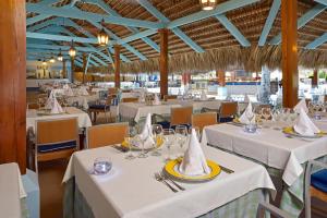 蓬塔卡纳蓬塔卡纳伊贝罗斯塔度假酒店的用餐室配有白色桌椅和餐巾