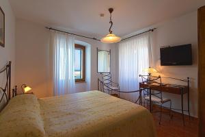 法扎纳维雷塔巴希亚娜酒店的一间卧室配有一张床、一张书桌和一台电视
