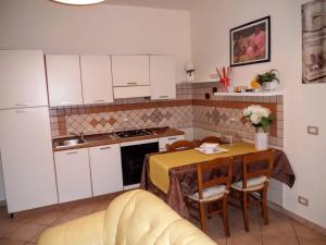 阿格里真托斯嘉丽塔酒店的一间带桌子的厨房和一间带白色橱柜的厨房