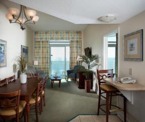 默特尔比奇Holiday Sands at South Beach的用餐室以及带桌椅的起居室。