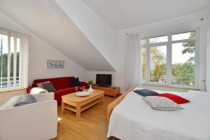 朱列斯拉赫Ferienwohnung Admiralssuite的一间卧室配有两张床和一张红色沙发