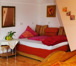 埃登科本Gasthaus Korfu的一间卧室配有红色和粉红色枕头的床