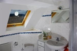 埃登科本Gasthaus Korfu的一间带水槽和卫生间的浴室以及窗户。