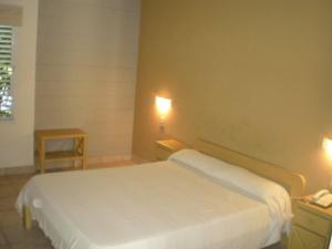 圣佩德罗Hotel Barrancas San Pedro的卧室配有白色的床和2个床头柜