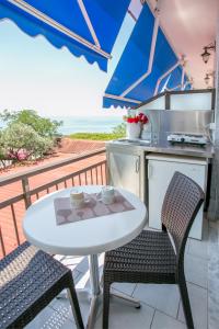 阿斯特里斯Astris Beach的阳台配有白色的桌椅和厨房