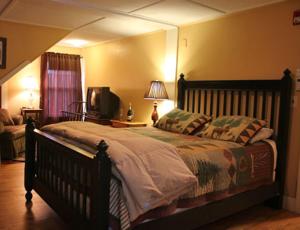 杰克逊野猫酒店及小酒馆的一间卧室配有一张大床和电视
