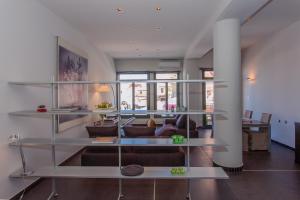 干尼亚Faro Apartments的客厅设有玻璃架和沙发