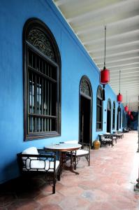 乔治市张弼士故居酒店 - 蓝色大厦的建筑中带桌子和长凳的蓝色墙