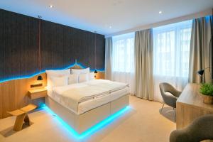 利贝雷茨皮特劳恩帝国大酒店的酒店客房配有一张带蓝色LED照明的床。