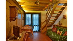 科尔蒂纳丹佩佐Cristallo & Faloria Suite Apartments的客厅设有绿色沙发和楼梯。