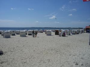 格罗森布罗德Apartment Seestern的沙滩上摆放着椅子,人们在沙滩上散步