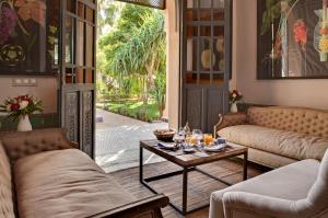 马拉喀什德奥广场酒店的客厅配有沙发和带玻璃杯的桌子