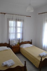 卡特瑞杜斯弗洛拉利亚公寓式酒店的配有2张床的白色墙壁和窗户客房
