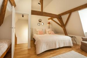 波佩林赫Skindles Guesthouse的一间卧室设有木梁和一张带粉红色枕头的床。