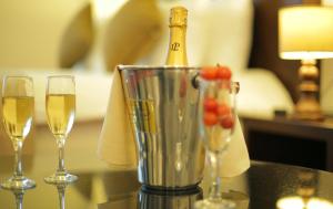 布拉柴维尔GHS酒店的桌子上的搅拌机上一瓶香槟和两杯