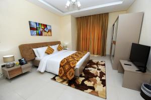 多哈Al Mansour Park Inn Hotel&Apartment的一间卧室配有一张大床和电视