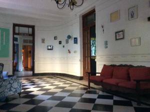 坦迪尔Casa Chango Hostel的客厅设有红色沙发和格子地板