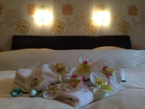 维安登Bed & Breakfast du Château的一间酒店客房,床上摆放着毛巾和鲜花
