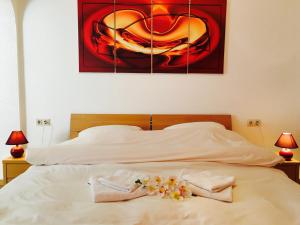 维安登Bed & Breakfast du Château的一张带两条毛巾的床和墙上的绘画