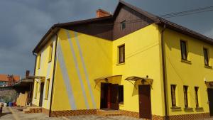 克拉斯拉瓦Hotel in Kraslava的黑色屋顶的大型黄色建筑