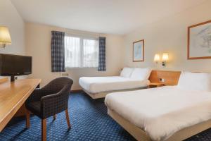 梅戈马戈尔戴斯酒店的酒店客房设有两张床、一张桌子和一台电视。