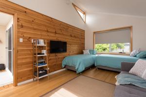 彭古因企鹅海滩度假屋的一间卧室设有两张床,墙上设有木饰。