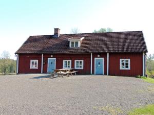 LönsbodaHjärtasjöstugor的前面的红色谷仓,设有野餐桌
