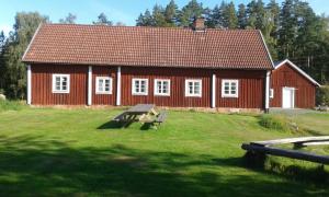 LönsbodaHjärtasjöstugor的前面有长凳的红色房子
