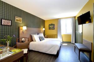 奥尔南Hôtel de France的配有一张床和一张书桌的酒店客房