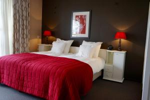 Tiendeveen马特斯普列克酒店的一间卧室配有一张带红色毯子的大床