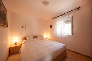 斯普利特卡Apartment Agata的一间卧室设有一张大床和一个窗户。