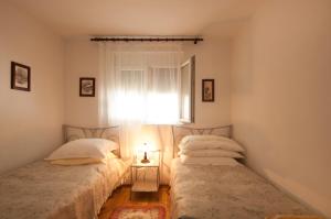 斯普利特卡Apartment Agata的带窗户的客房内设有两张单人床。