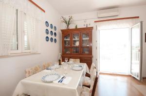 斯普利特卡Apartment Agata的白色的用餐室配有桌椅