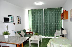 波多黎各IG MOMOSOL Apartments的客厅配有绿帘和桌子