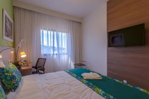 瓦利尼乌斯瓦林和斯蓝树酒店的酒店客房,设有一张带平面电视的床铺。