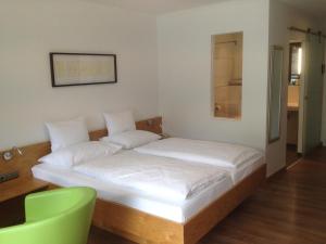 施特罗布尔丽丽湖畔酒店的一张位于带绿椅的房间的床位