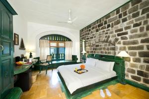 蒂鲁瓦纳马莱斯帕拉特鲁瓦纳玛莱度假酒店的一间卧室设有一张床和石墙
