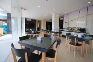 巴淡岛中心OS Hotel Airport Batam的用餐室配有黑色的桌椅