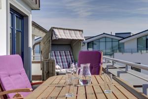 伯尔格伦德-雷特维施伯尔格伦德海滩公寓酒店的阳台的一张木桌和紫色椅子