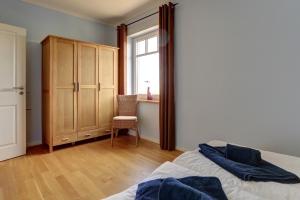 伯尔格伦德-雷特维施伯尔格伦德海滩公寓酒店的卧室配有床、椅子和窗户。
