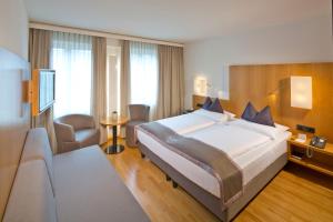 因斯布鲁克马克西米利安彭茨市政厅酒店的一间位于酒店客房内的带大床的卧室